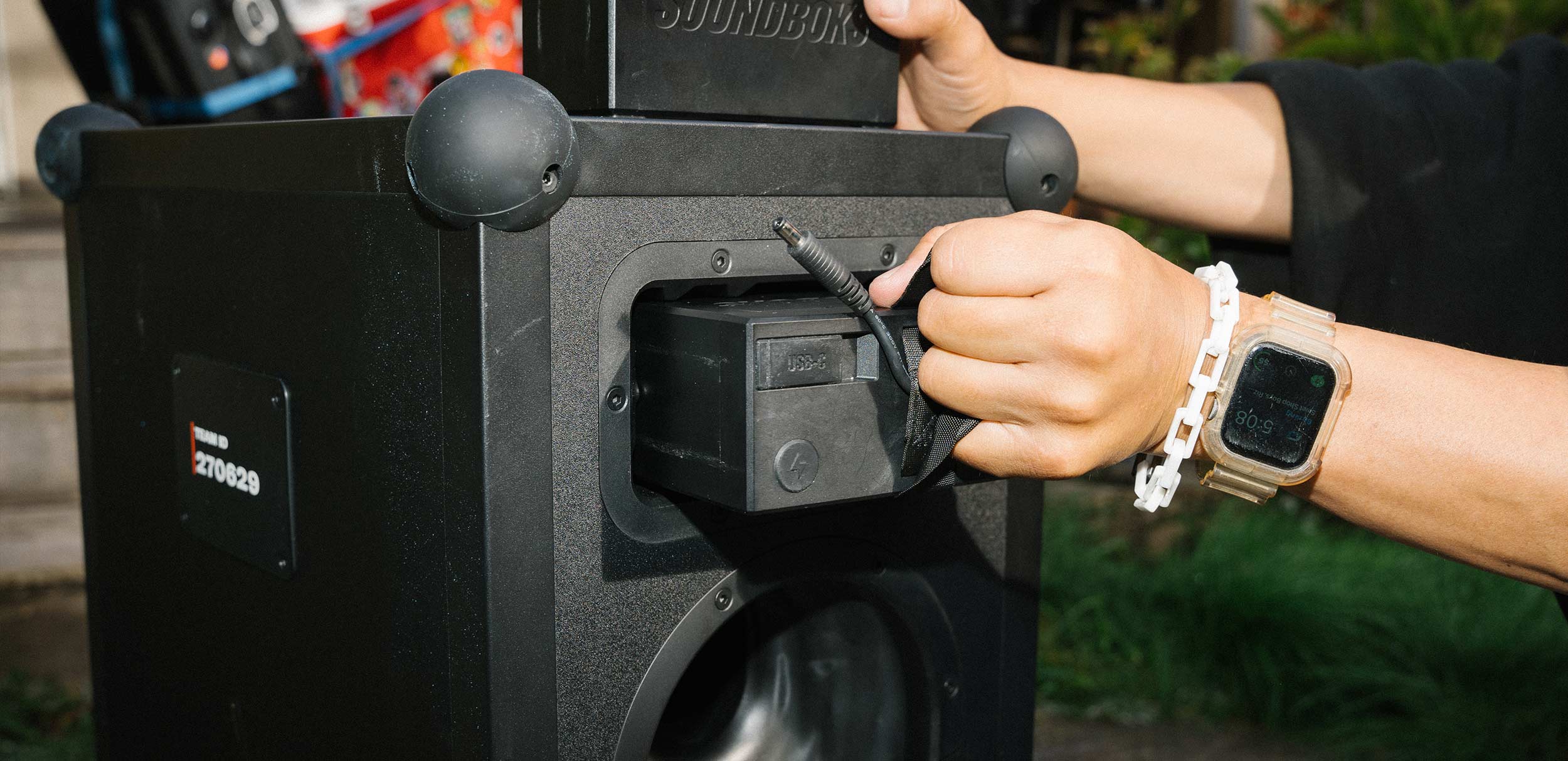 Close-up of a person pulling out THE BATTERY from a SOUNDBOKS 4 party speaker